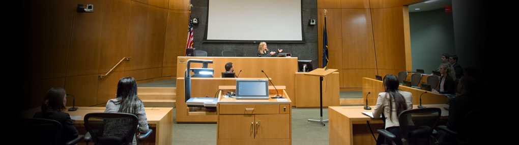 A judge talks with law students at Penn State University Park as part of mock trial exercises in a courtroom.